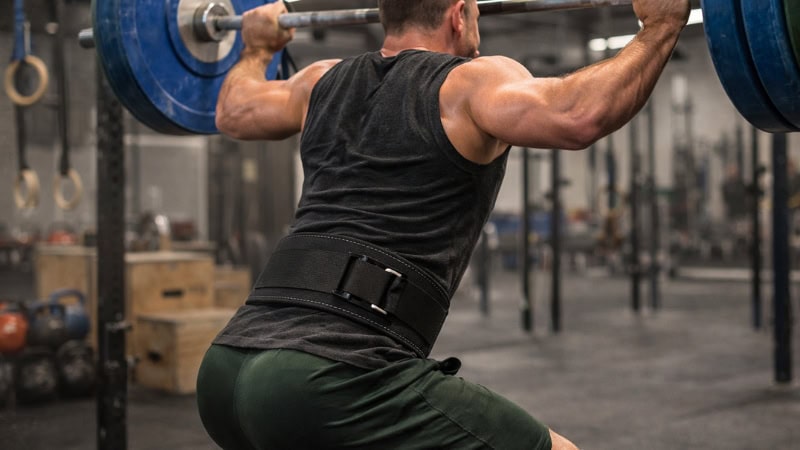 Athlete wearing a nylon lifting belt performing an Olympic lift.